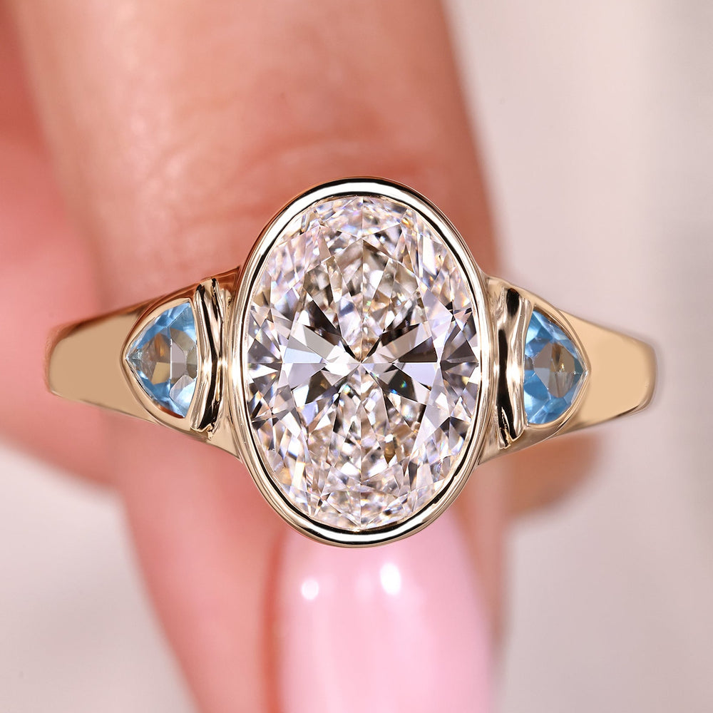 Bezel set oval diamond ring in yellow gold setting.