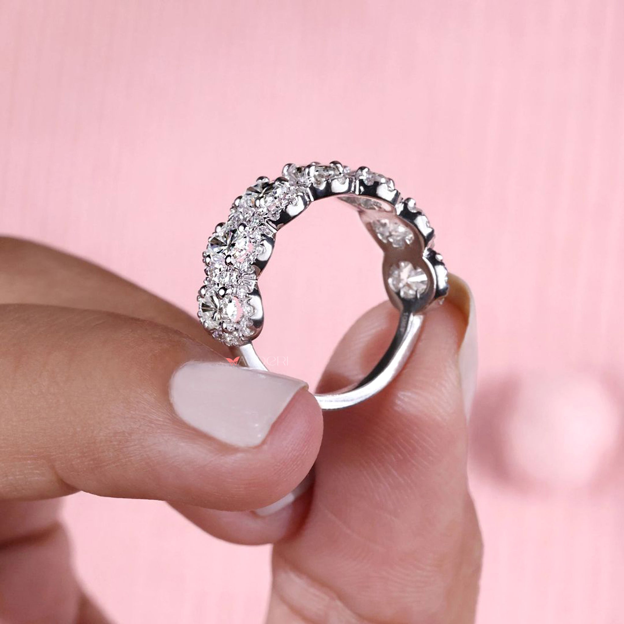 Oval wedding band with round moissanite halo design.