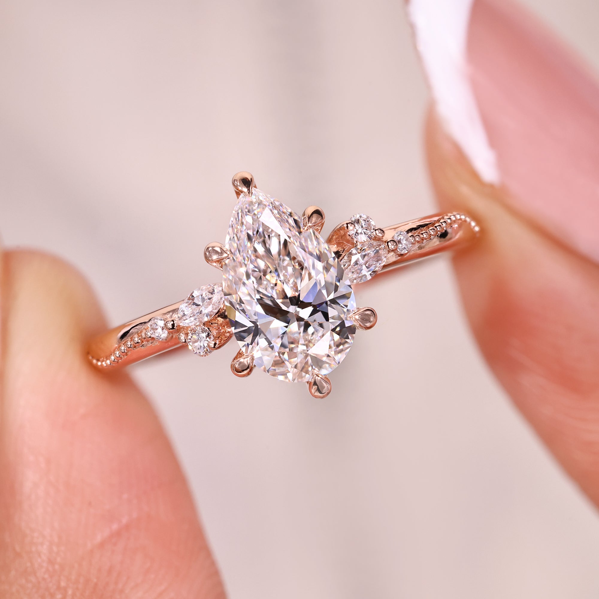 Marquise and round side stone on rose gold engagement ring.