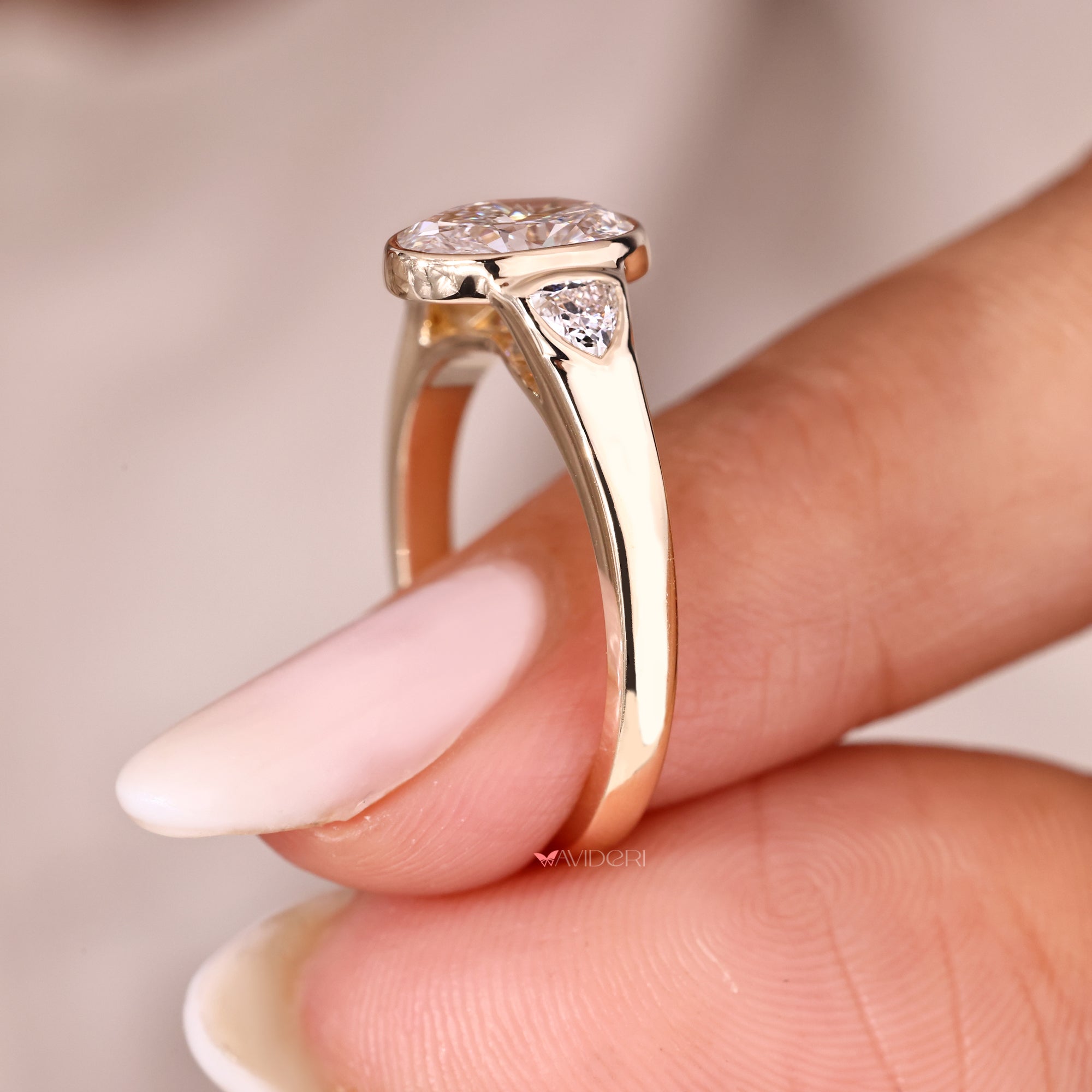 Bezel set oval diamond ring with cathedral setting.