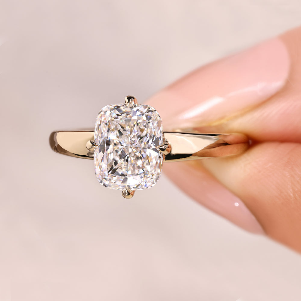 Solitaire cushion ring with claw prong detail.
