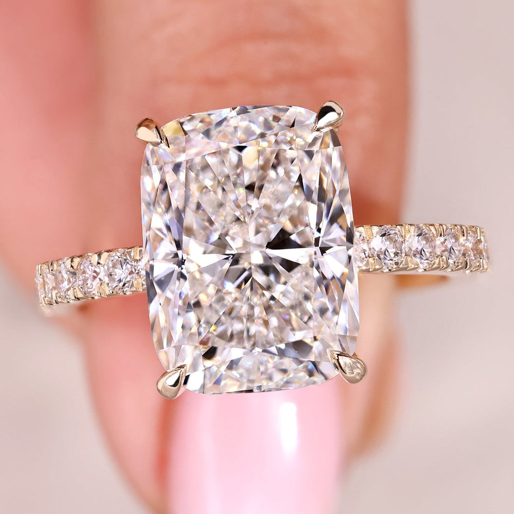 Cushion cut diamond ring with round diamond pave band.
