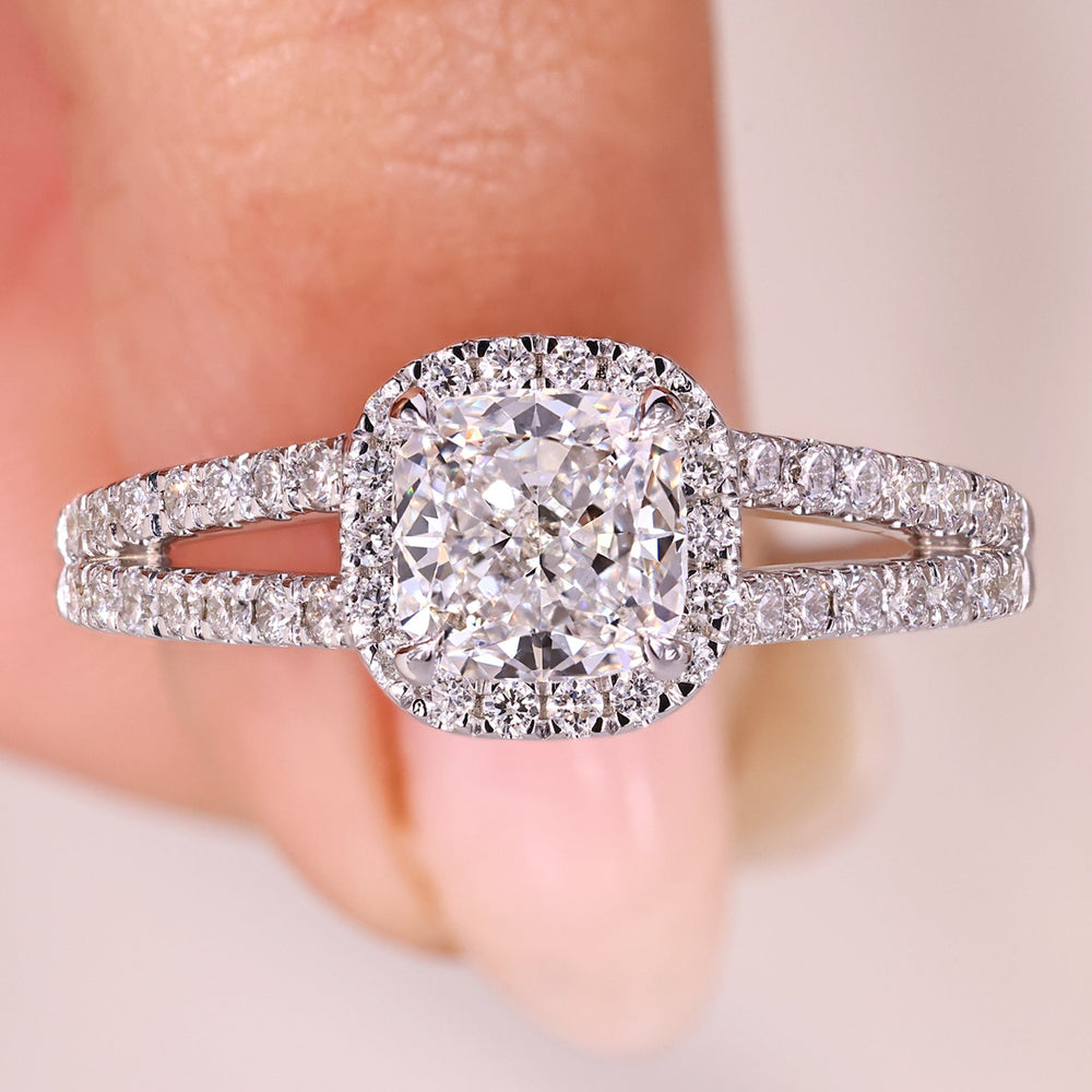 Cushion cut diamond ring with halo and split shank pave band.
