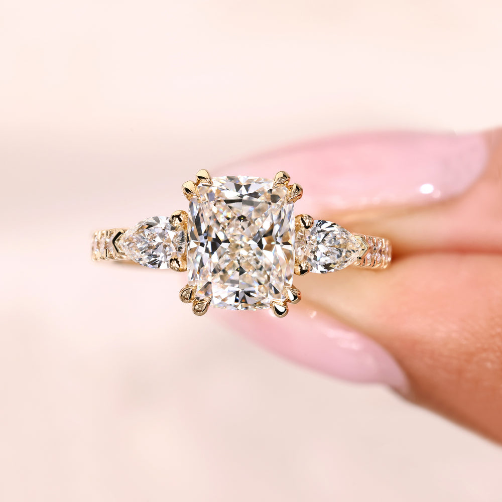Cushion ring with pear side stones and pave band.
