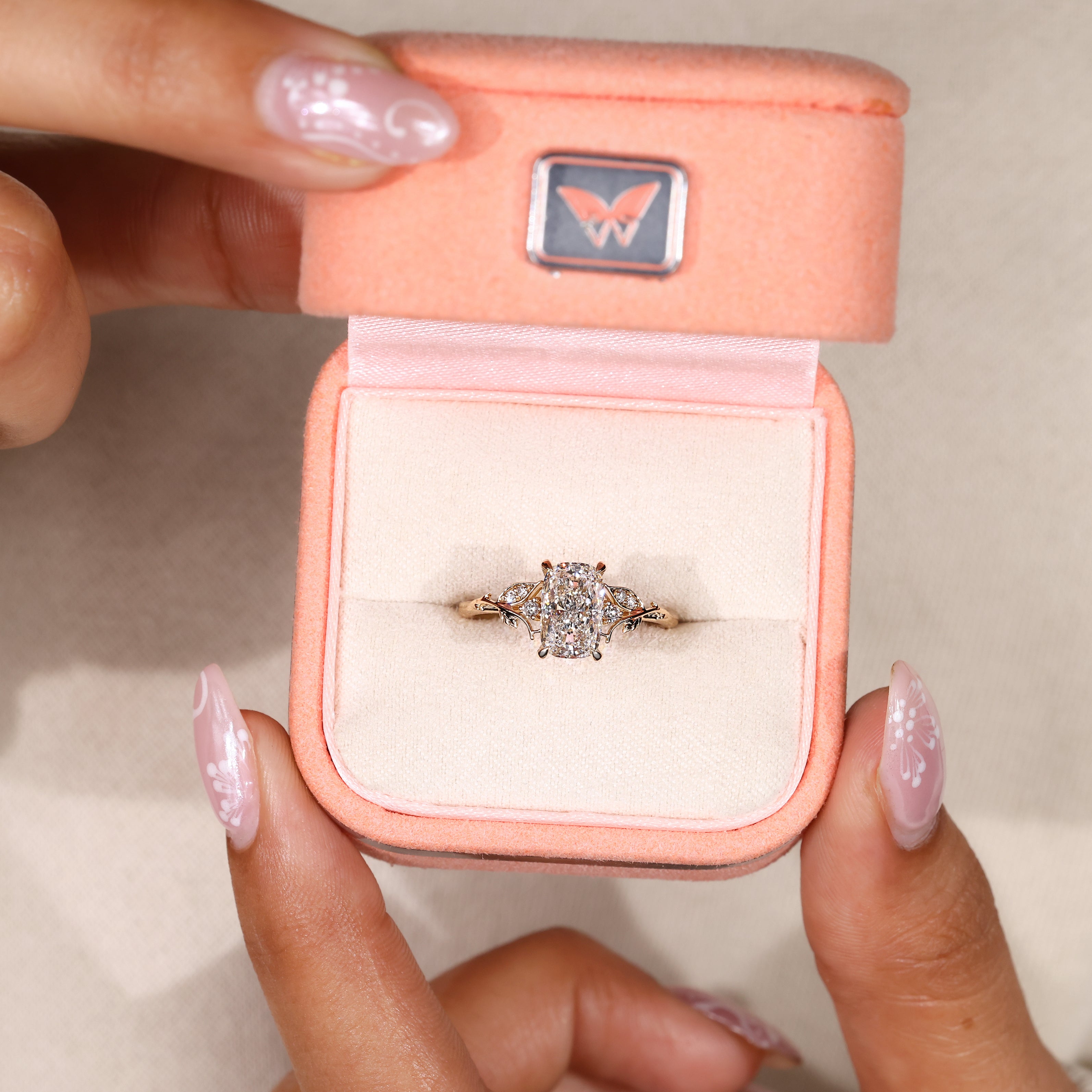 Claw prong cushion diamond ring with leaf accents.
