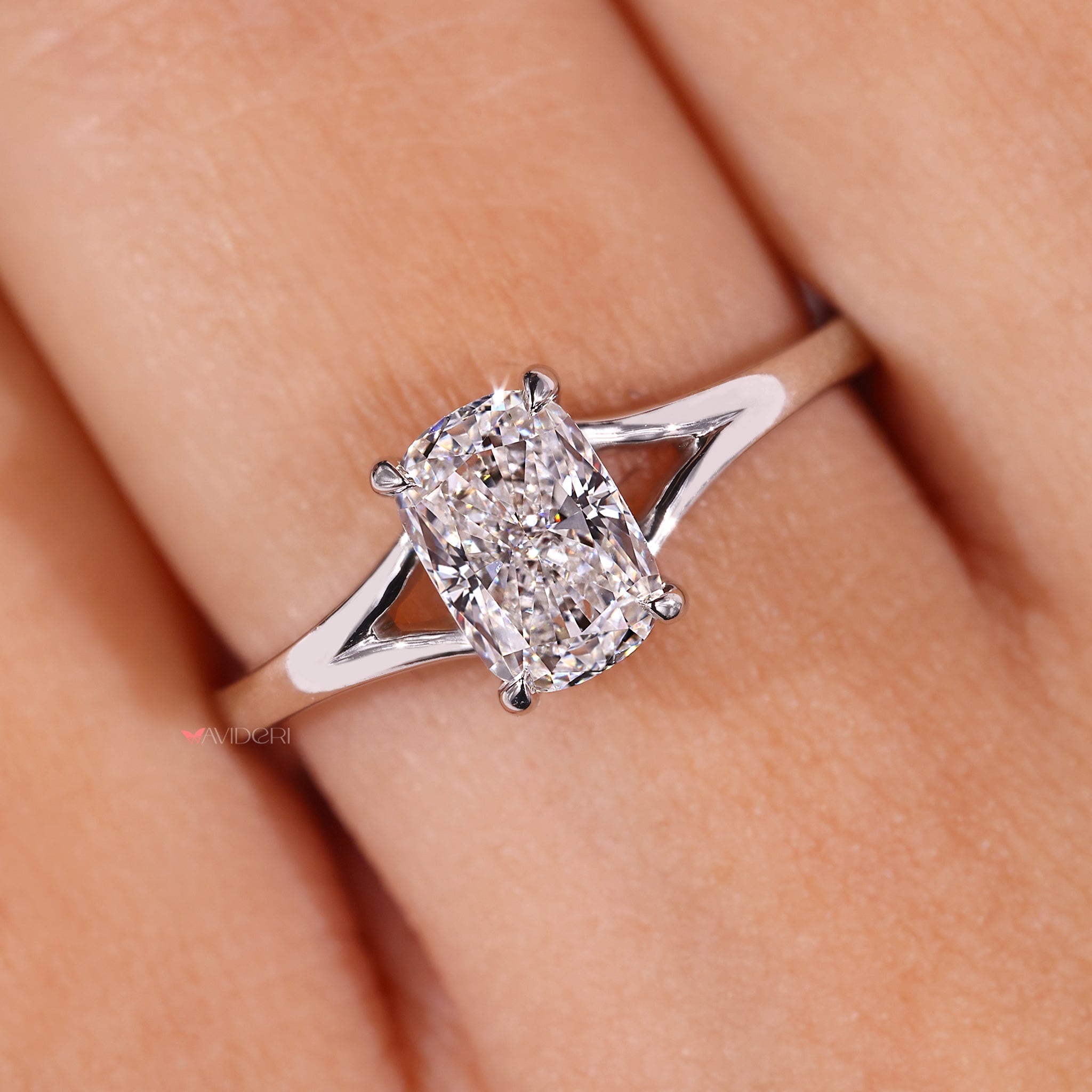 Split shank ring with a cushion cut diamond in a white gold setting.