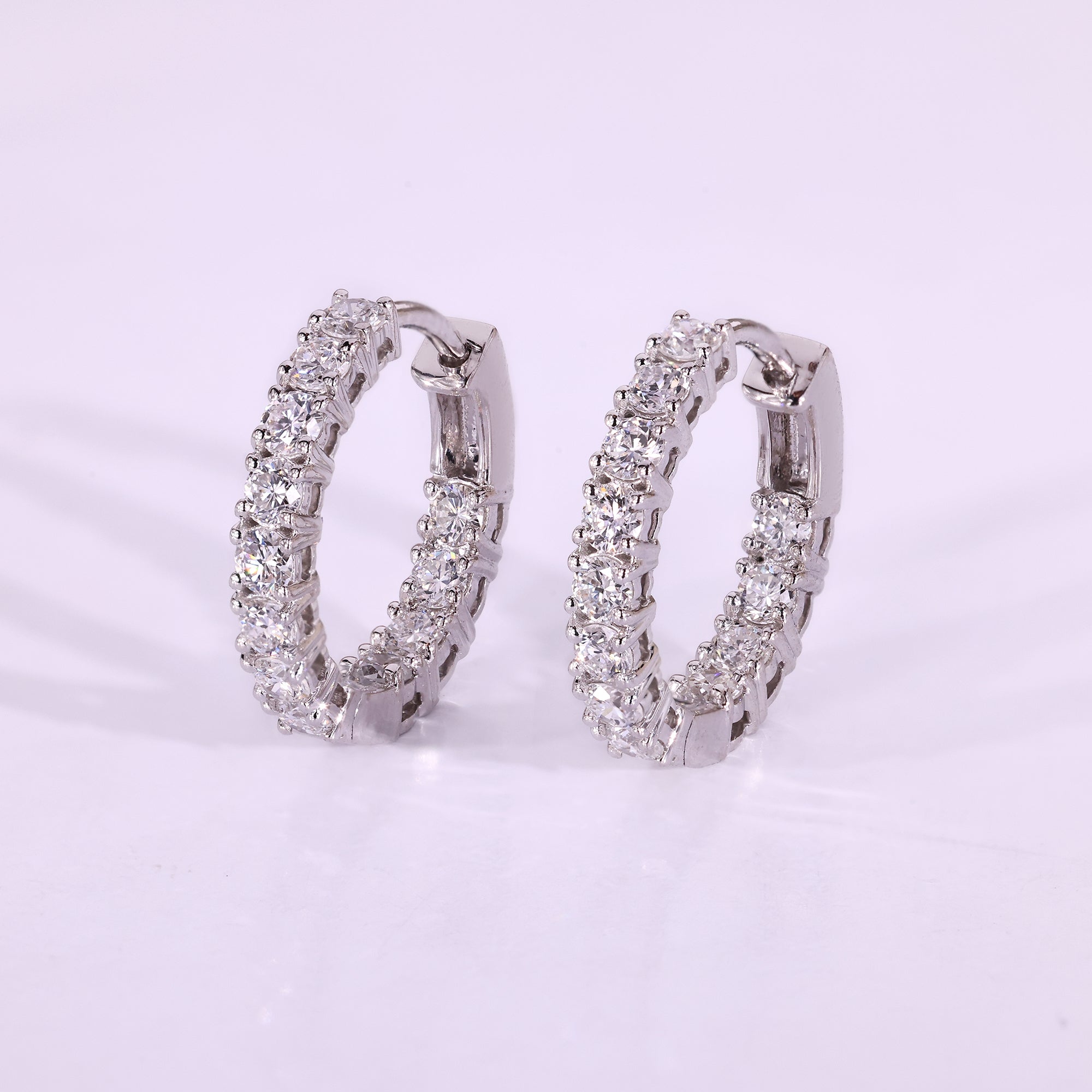 Round diamond earrings set in white gold hoops.