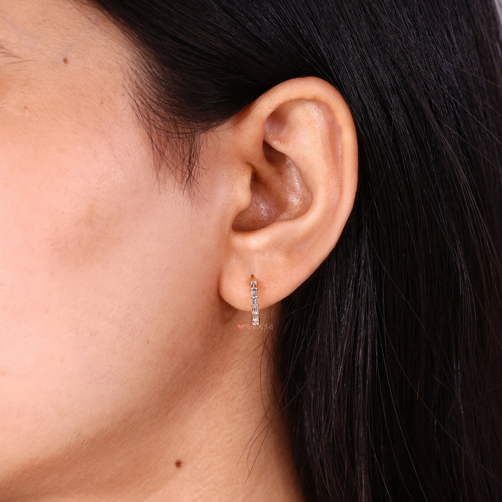 Set of white gold baguette earrings on a stand
