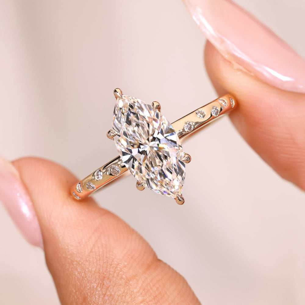 Marquise ring with flush pave round diamonds.
