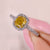 Cushion cut yellow diamond ring with halo and pave style.
