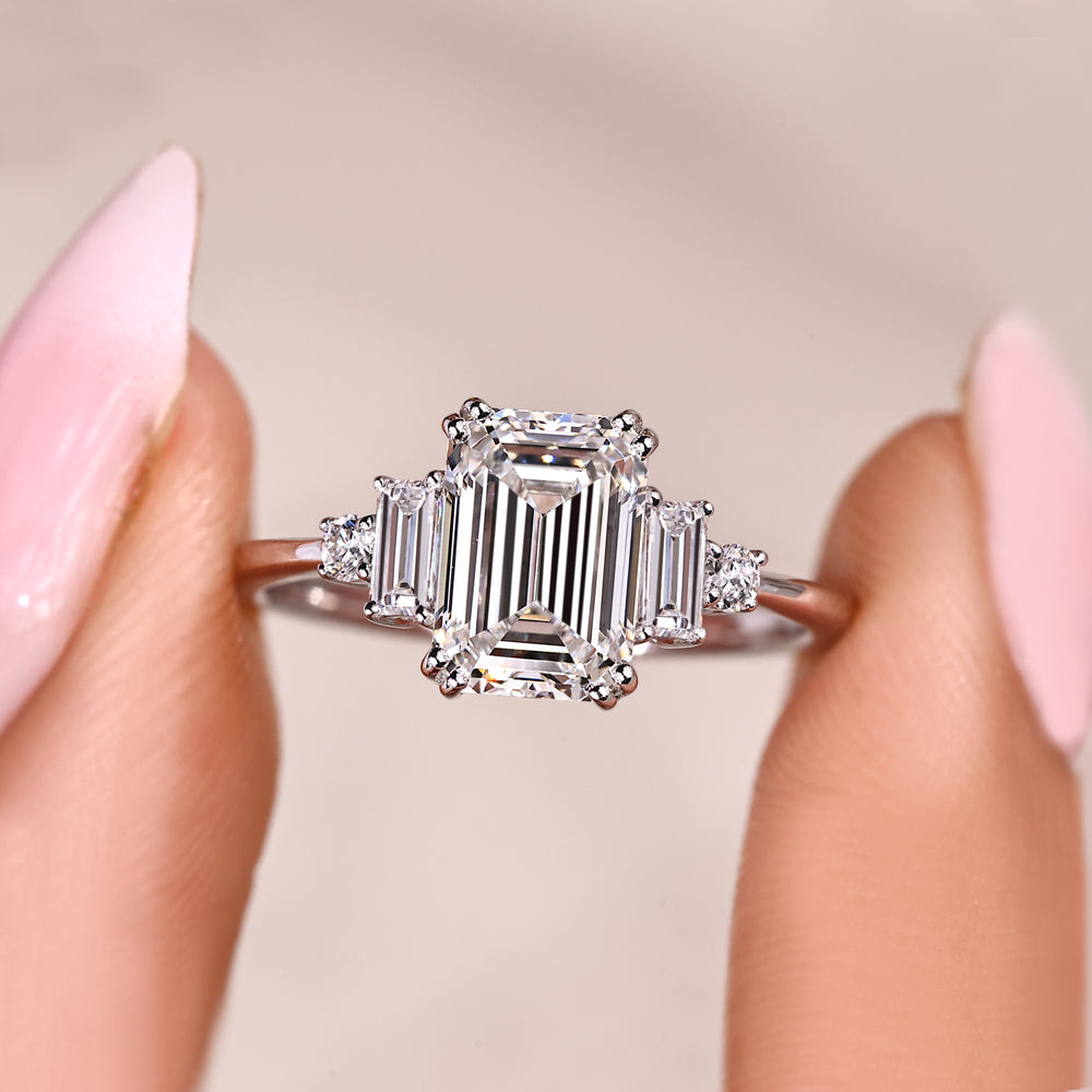 Emerald cut diamond ring with baguette and round sides.
