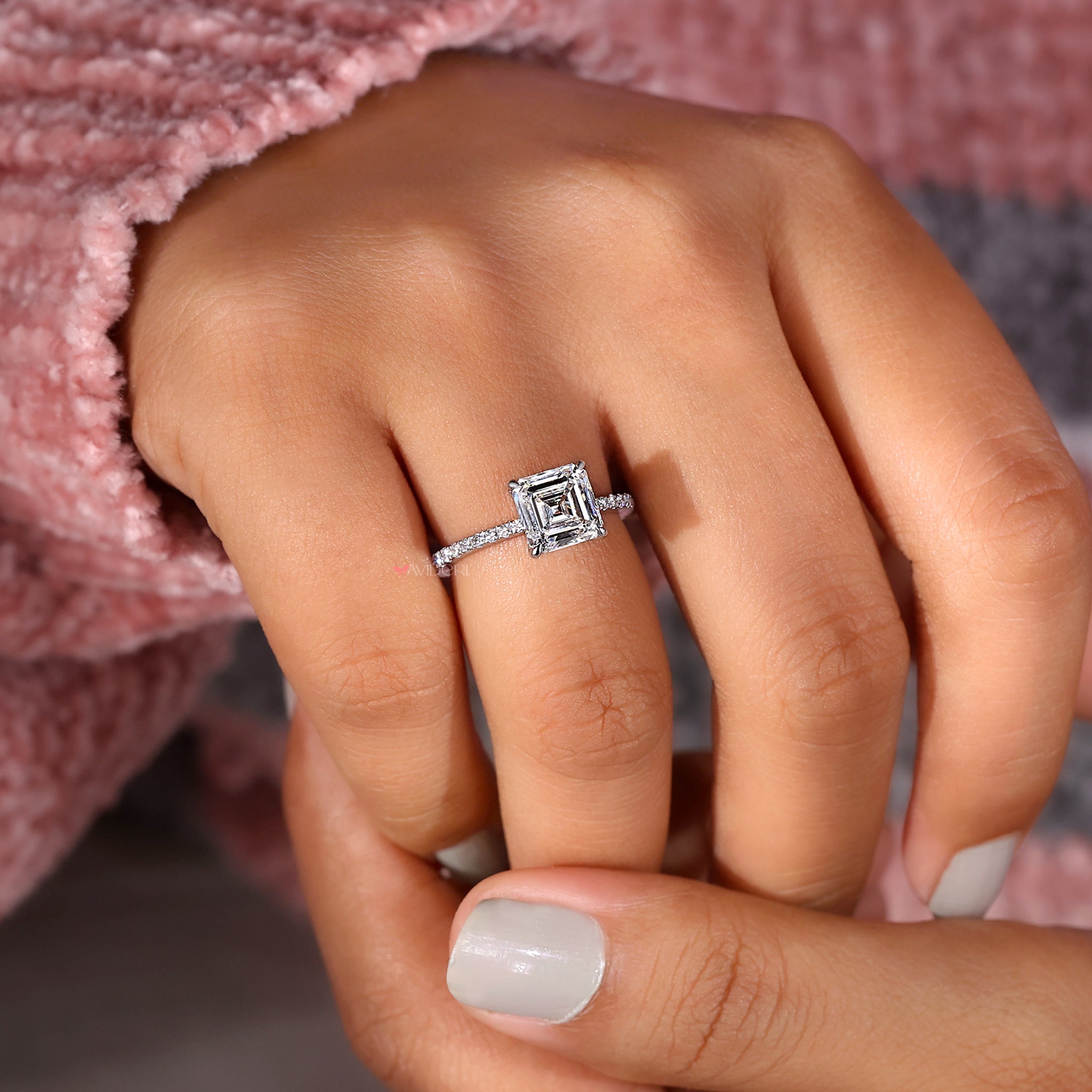 Asscher cut diamond ring featuring round diamond pave accents.
