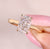 Cushion cut diamond ring with solitaire cathedral setting.
