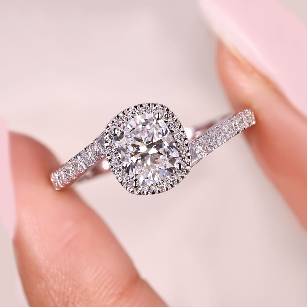 Cushion cut diamond ring with halo and pave style.
