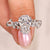 Coffin Diamond ring held by a hand with a soft pink background