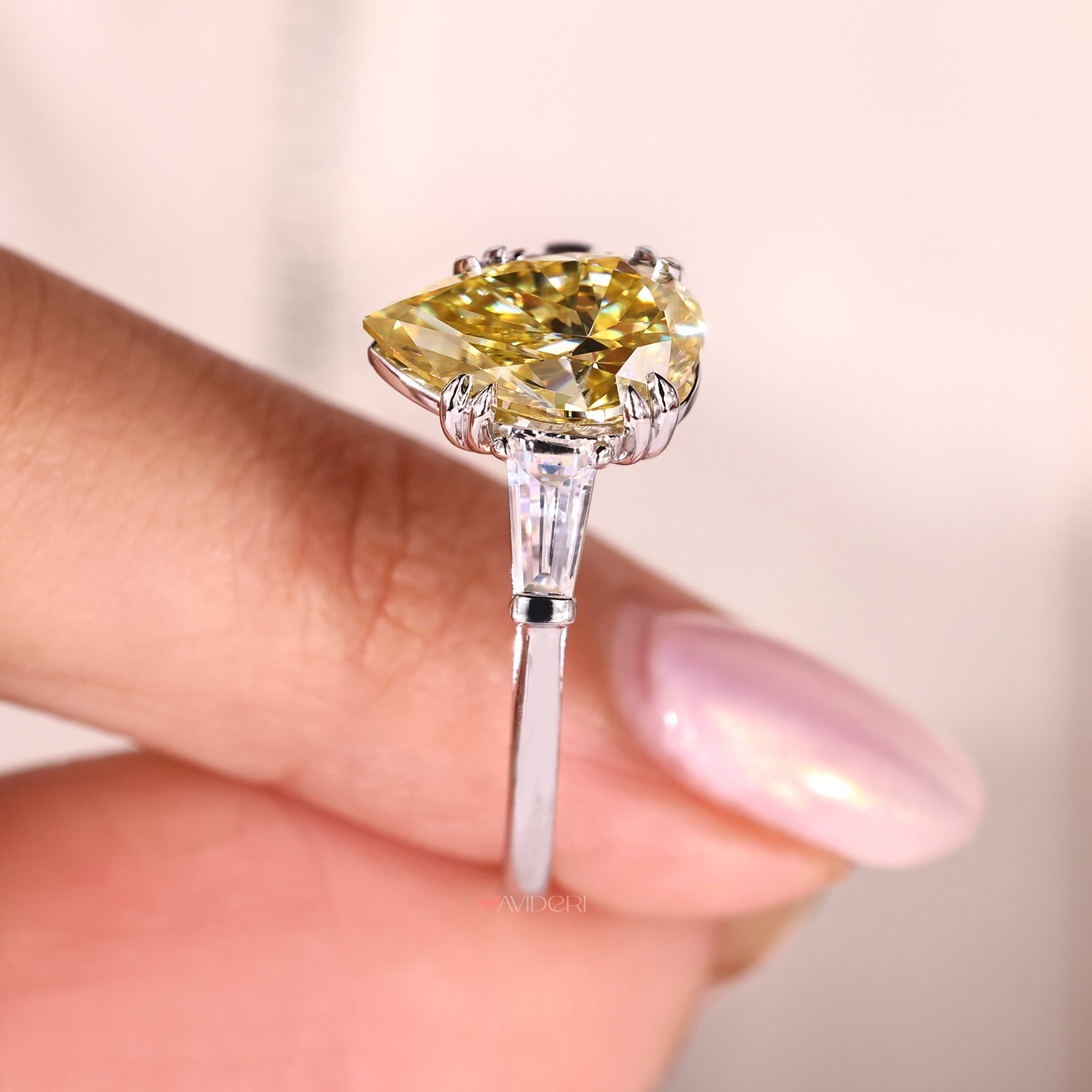 Canary Yellow pear cut engagement ring featuring tapered baguette side stones in white gold.
