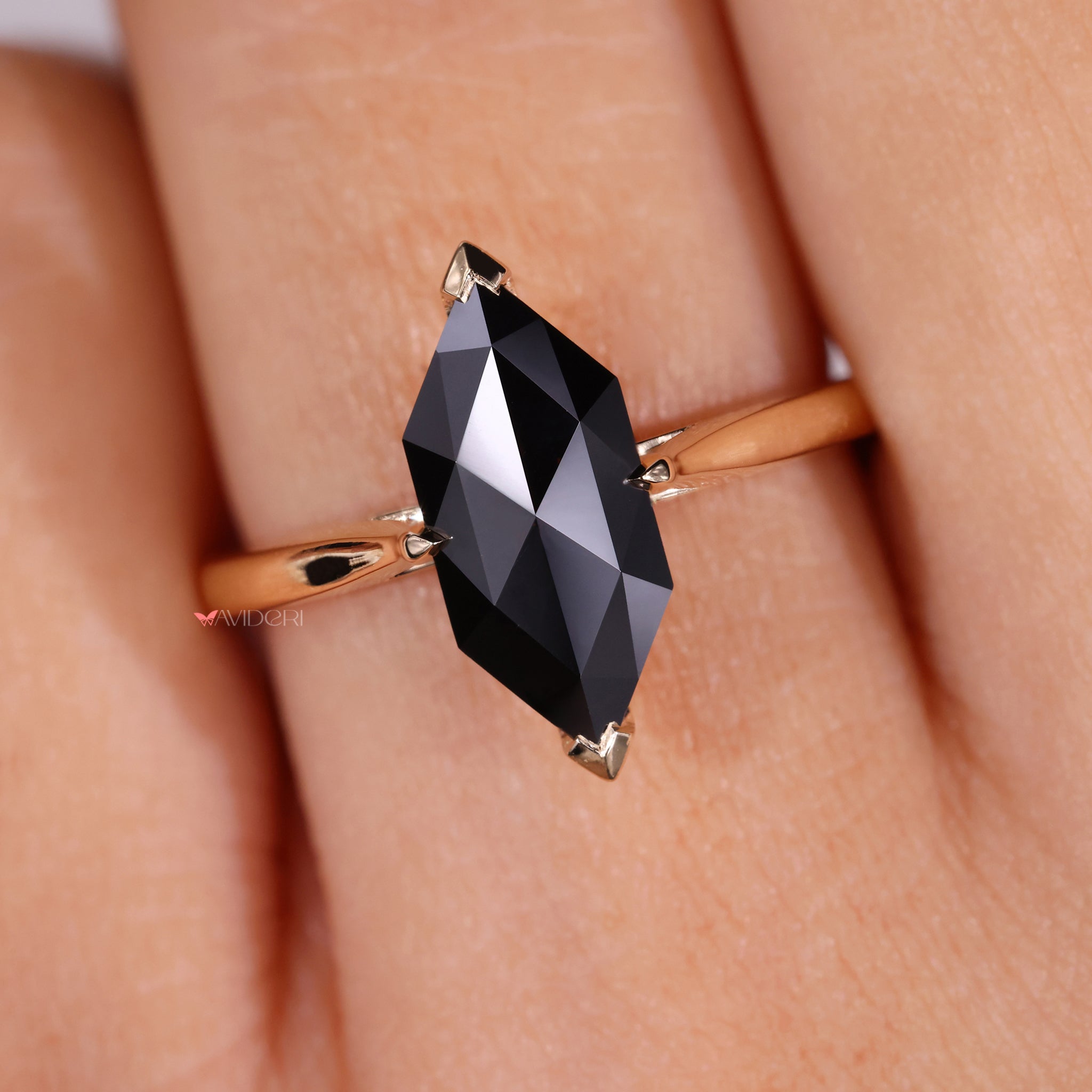 A black moissanite ring with a unique tapered shank design.
