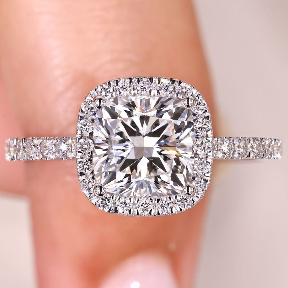 Cushion cut diamond ring with halo and pave style.
