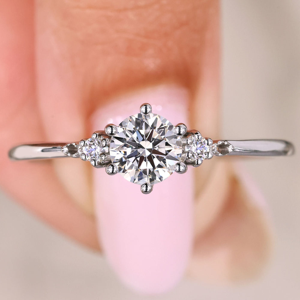 This 3 stone engagement ring features a stunning center stone flanked by two side stones.