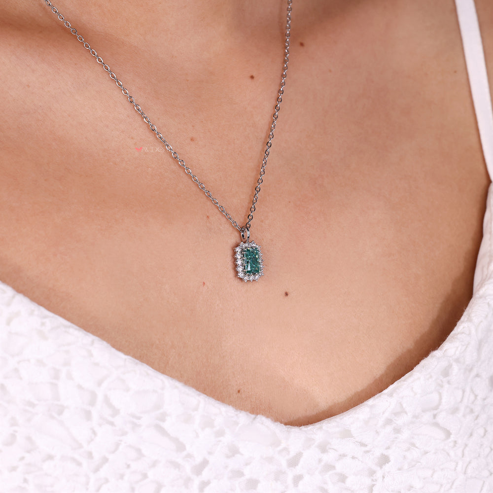 Cyan blue moissanite halo pendant with radiant cut stone.
