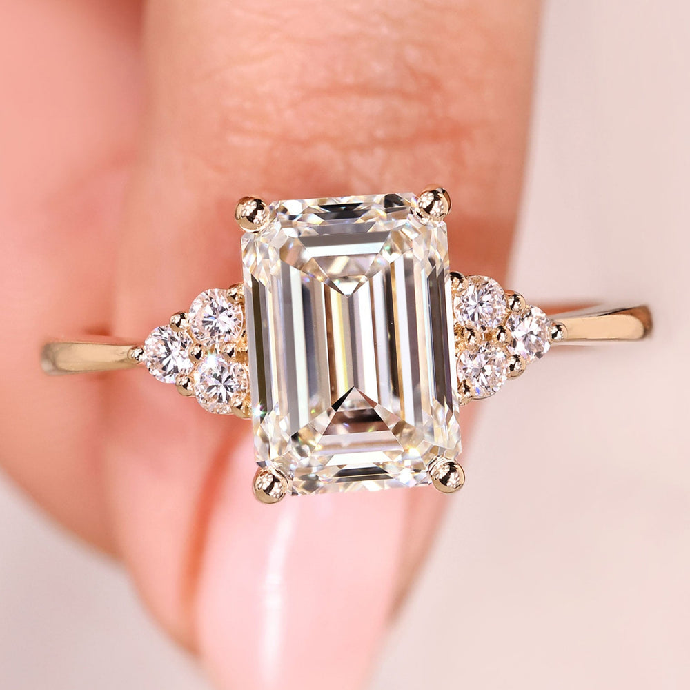 Emerald cut diamond ring with round side stones.
