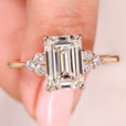 Emerald cut diamond ring with round side stones.
