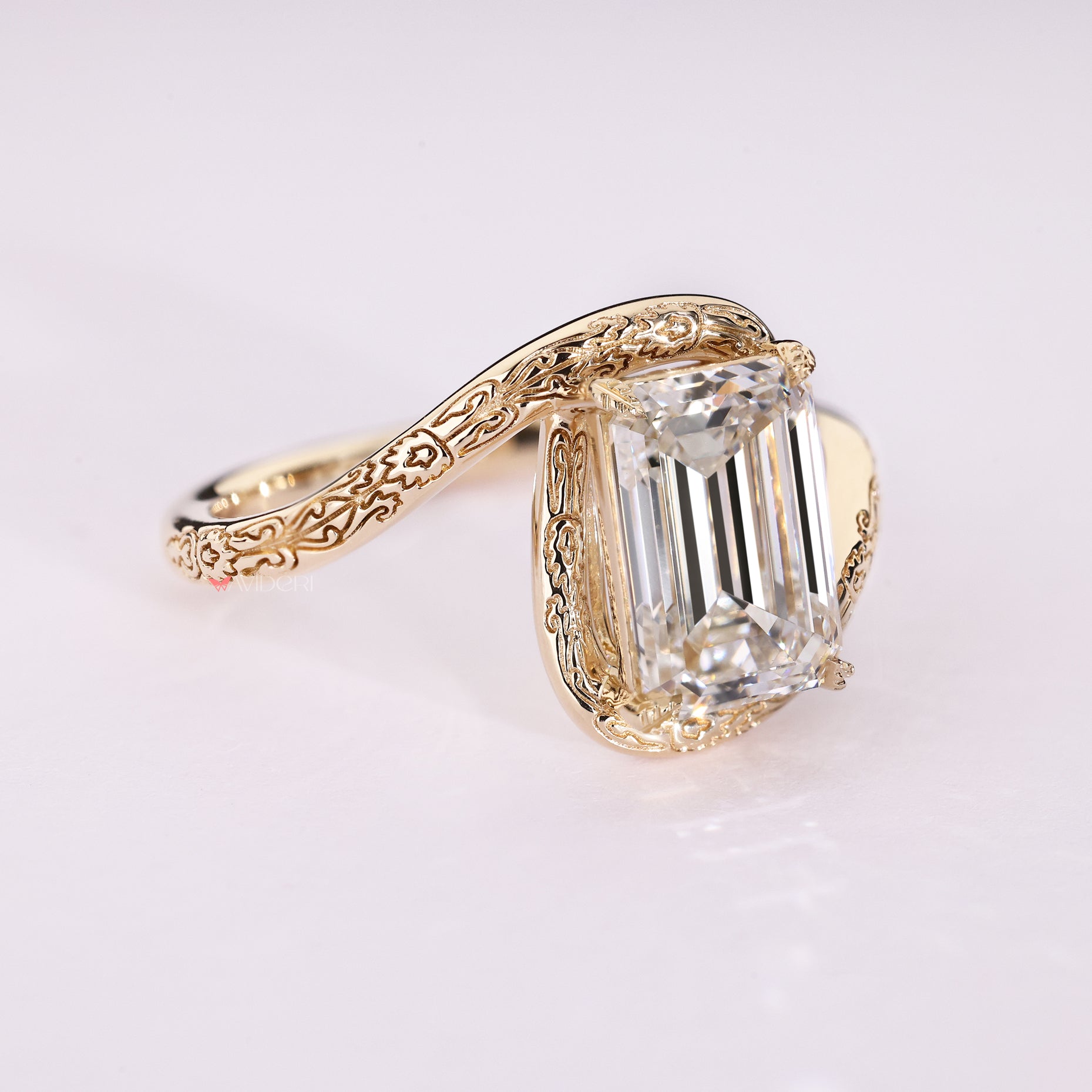 Emerald diamond ring with leaf prong detailing.
