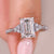 Emerald cut diamond engagement ring with pave band.
