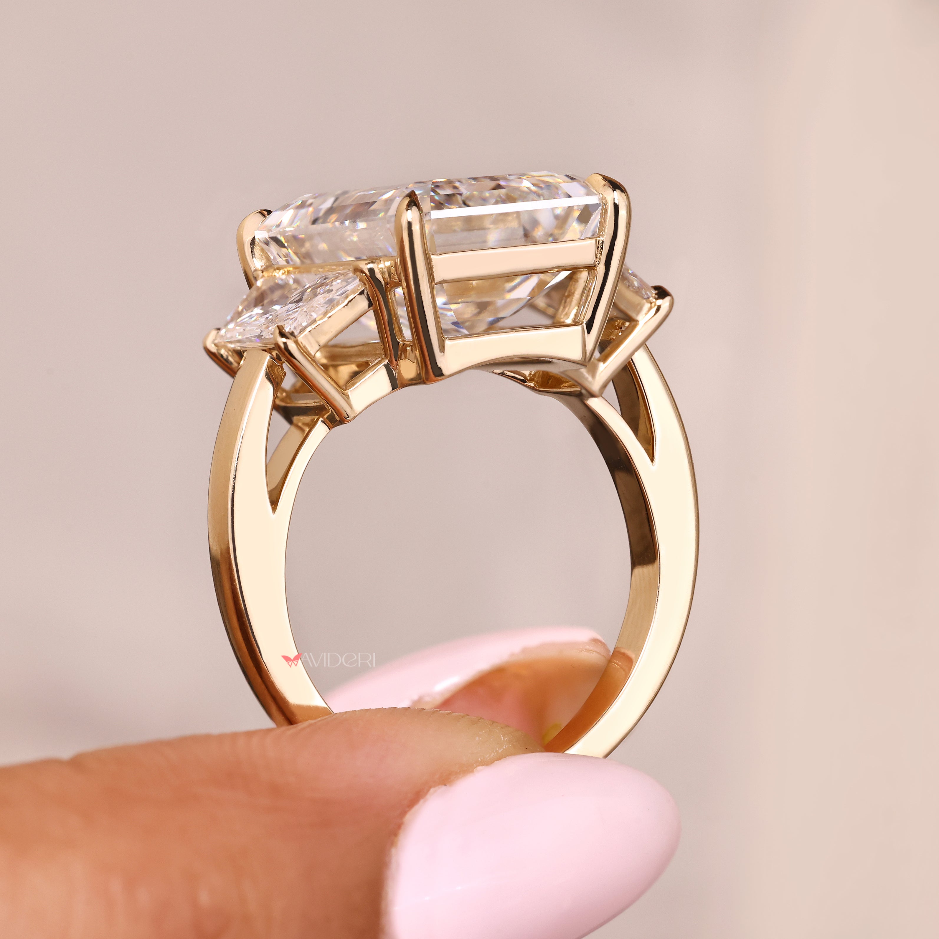 Three stone emerald diamond ring with four claw prongs
