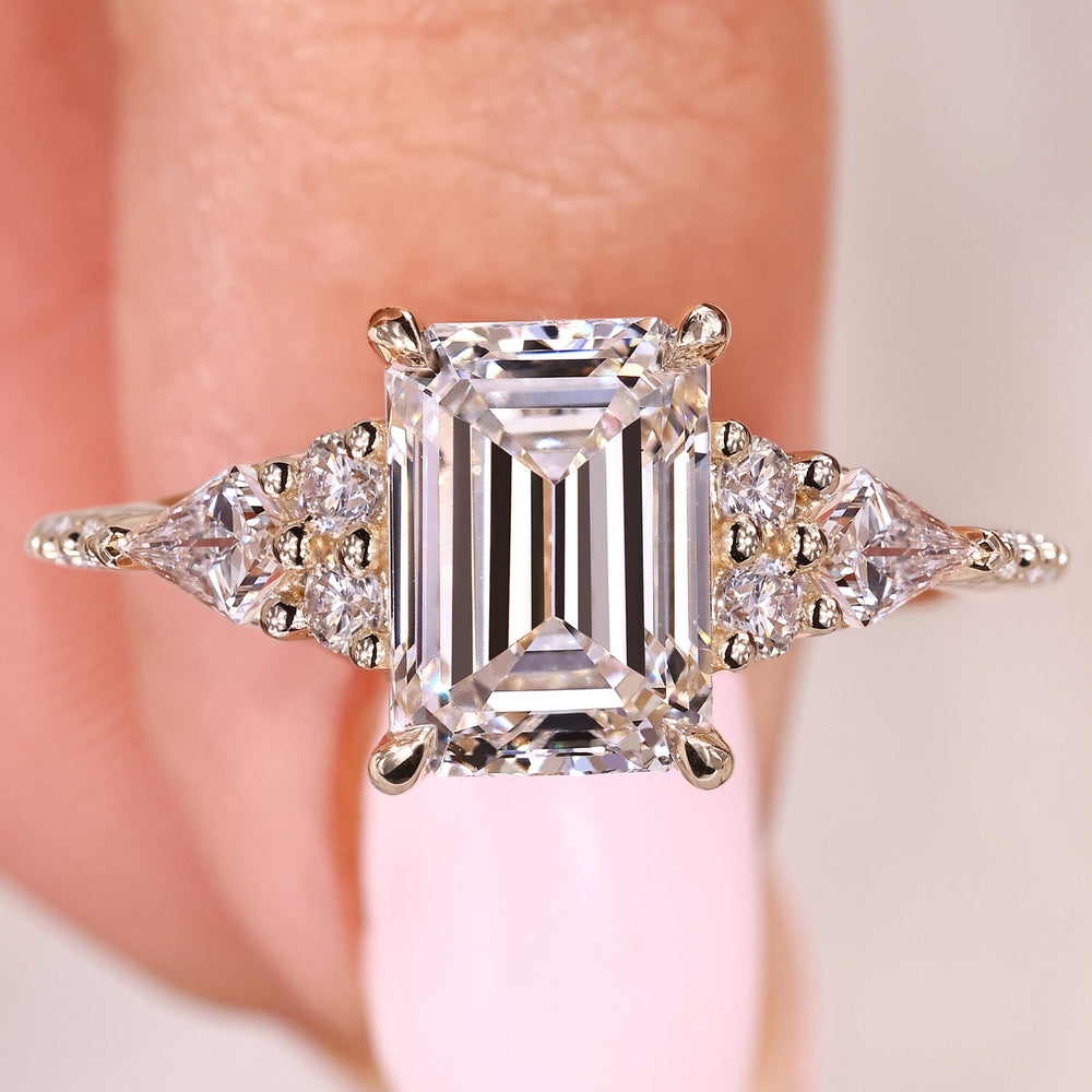 Emerald cut engagement ring with kite and round stones

