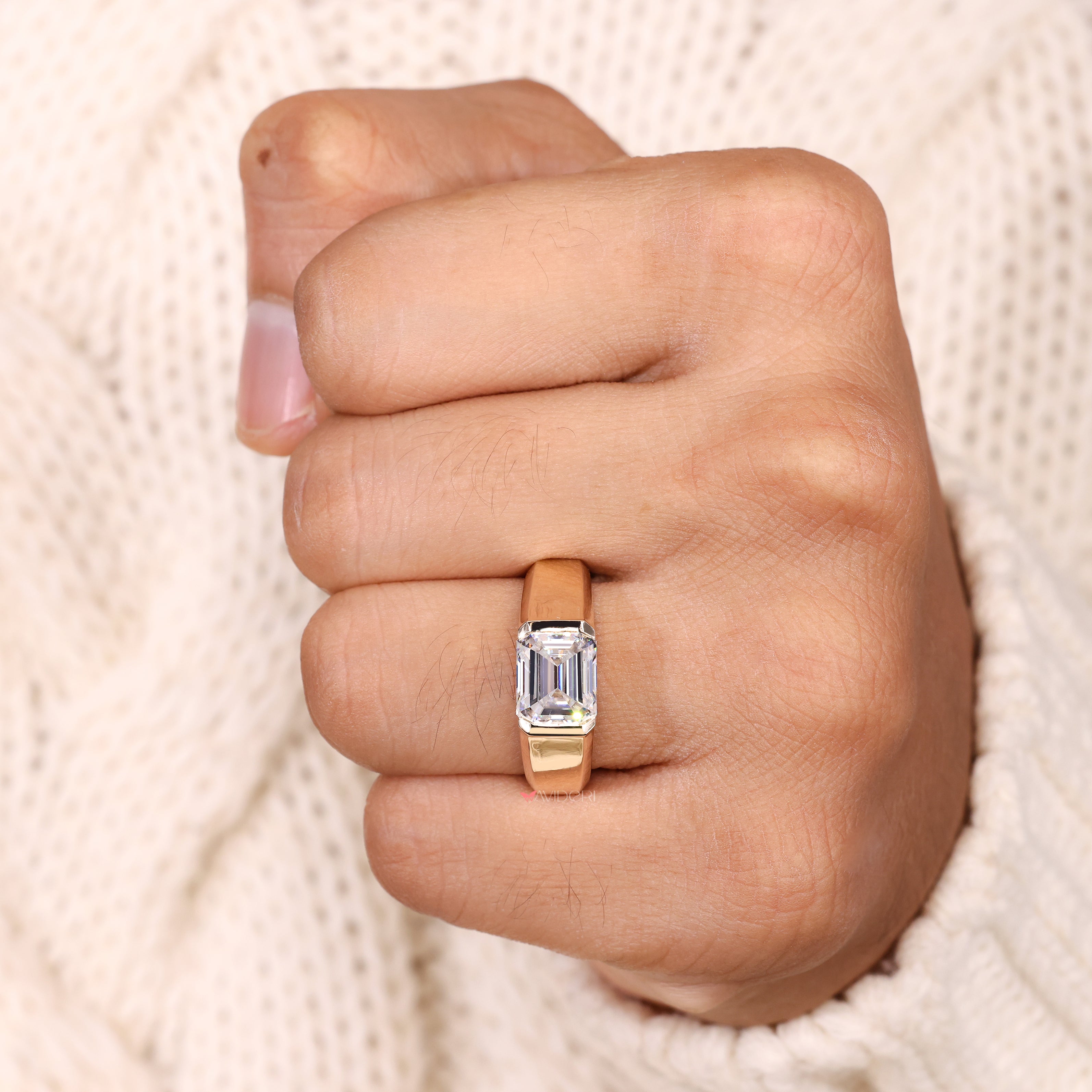 Solitaire emerald cut ring bezel set style.
