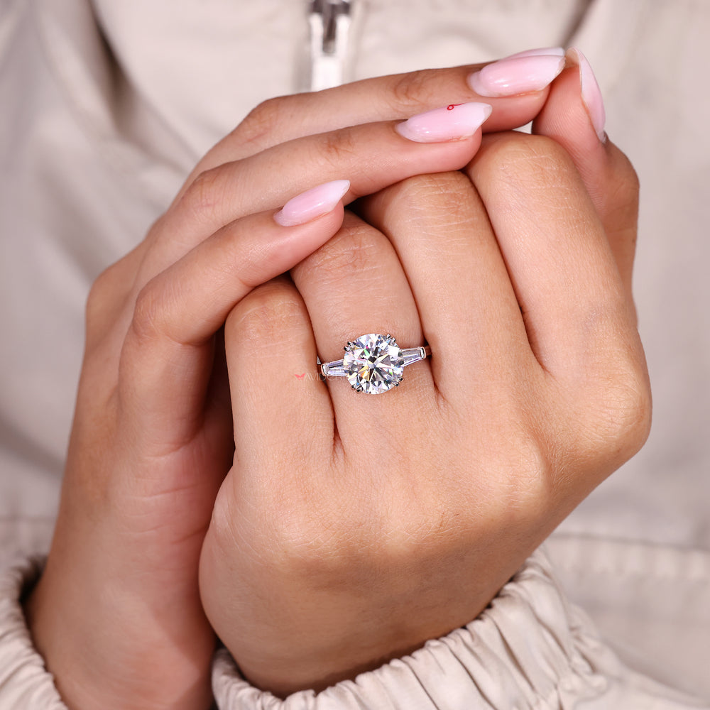 Three stone moissanite ring with tapered baguette sides.
