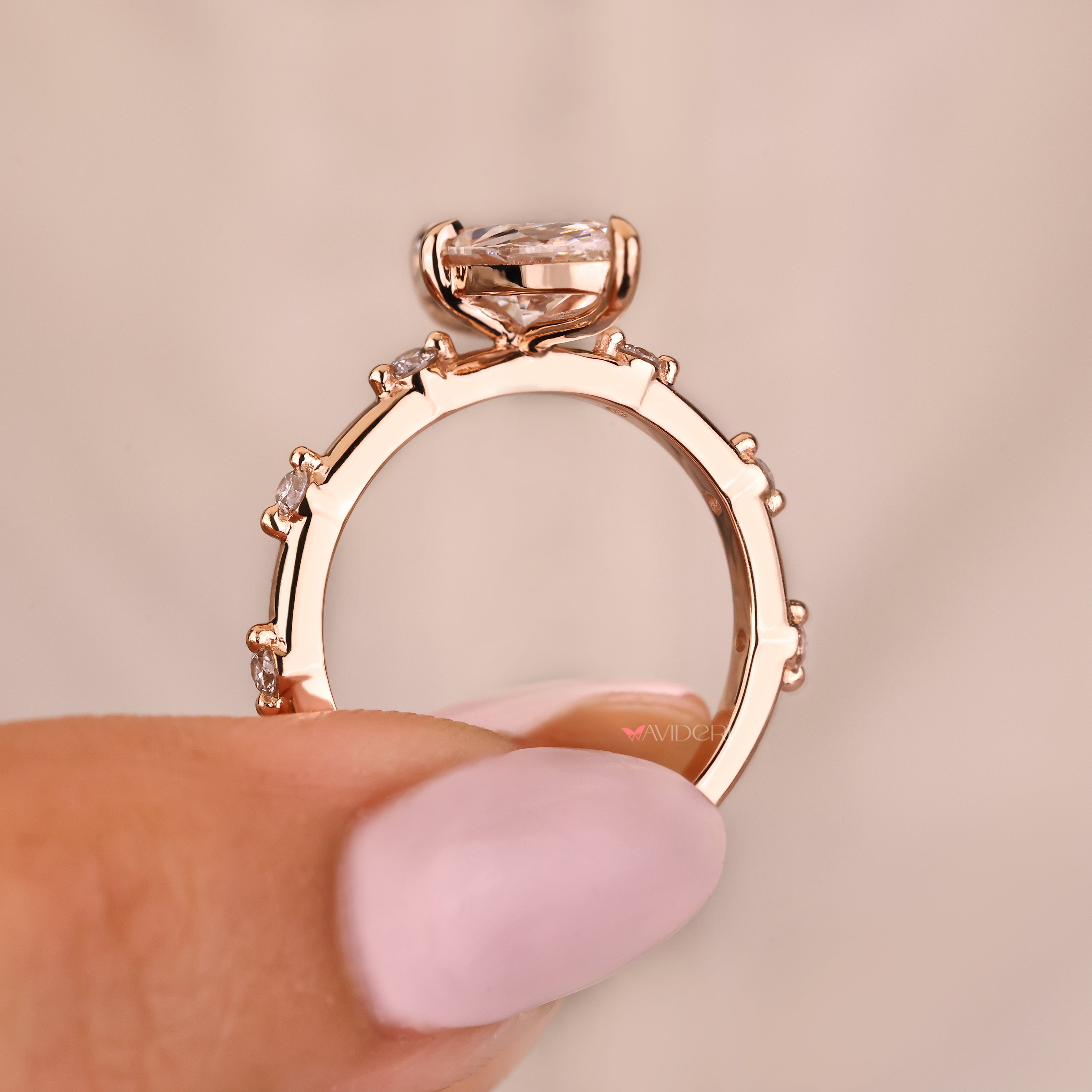 Elongated marquise ring with round diamond pave style details
