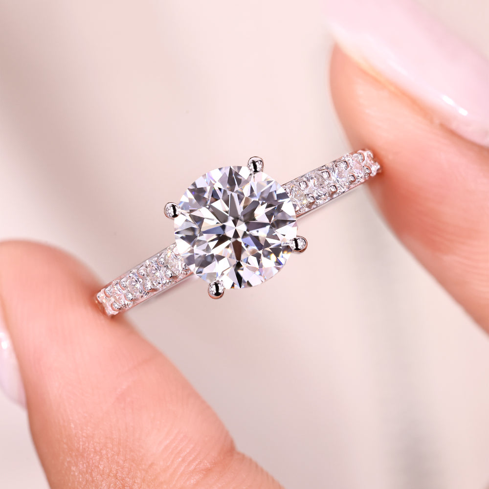 Elegant round diamond ring with pave accents.
