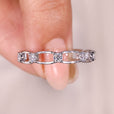 Round moissanite eternity wedding band with link style.
