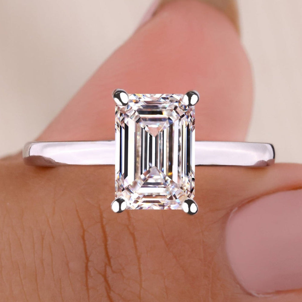 Emerald cut engagement ring with lab grown diamond in a classic prong setting.
