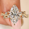 Marquise diamond ring with round side stones and leaf prongs
