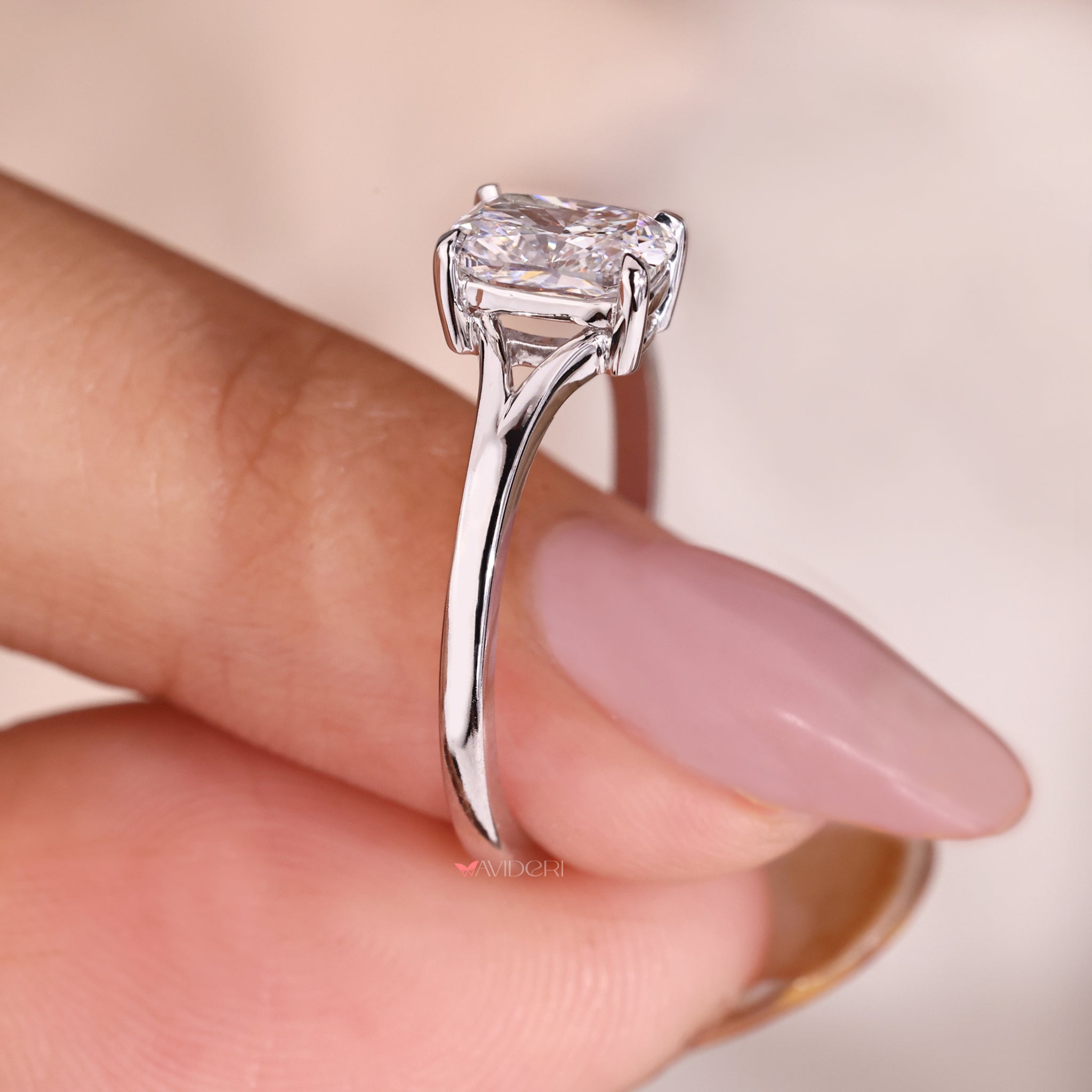Split shank ring with a cushion cut diamond in a white gold setting.