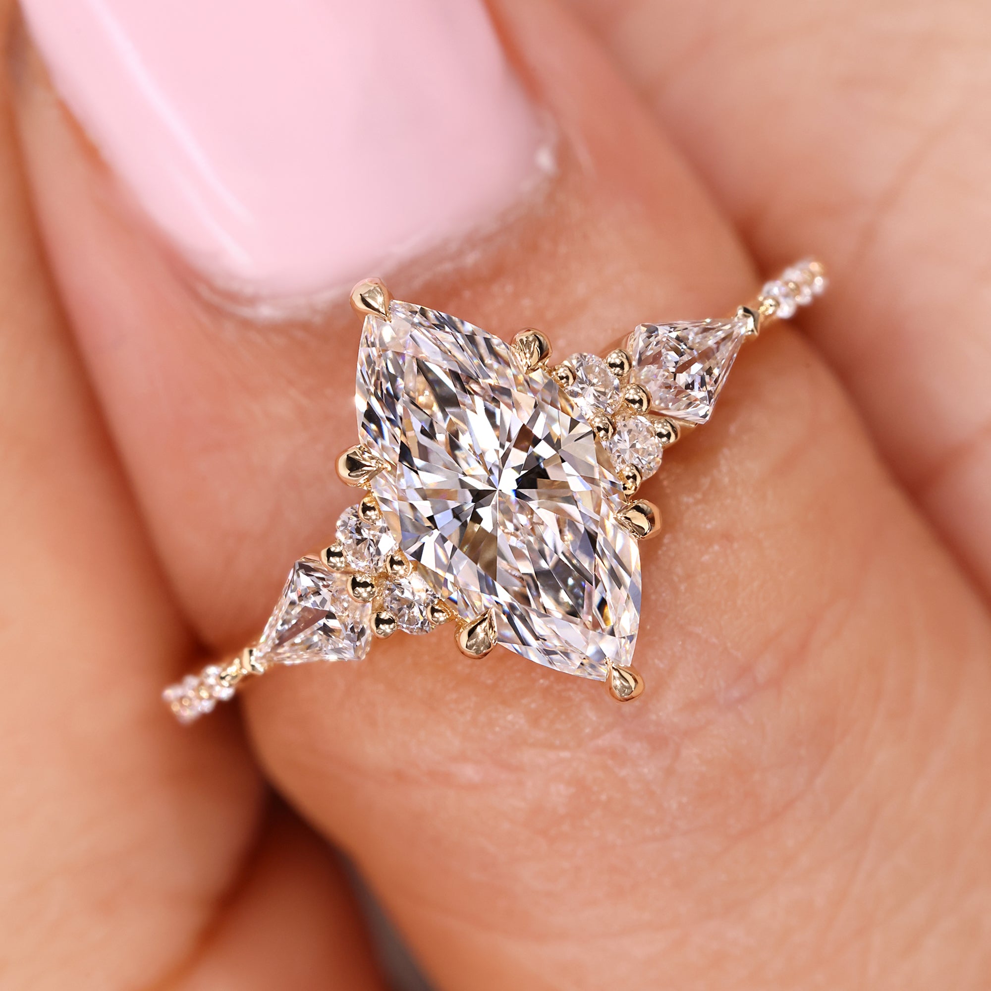 Marquise diamond ring with kite and round accents.