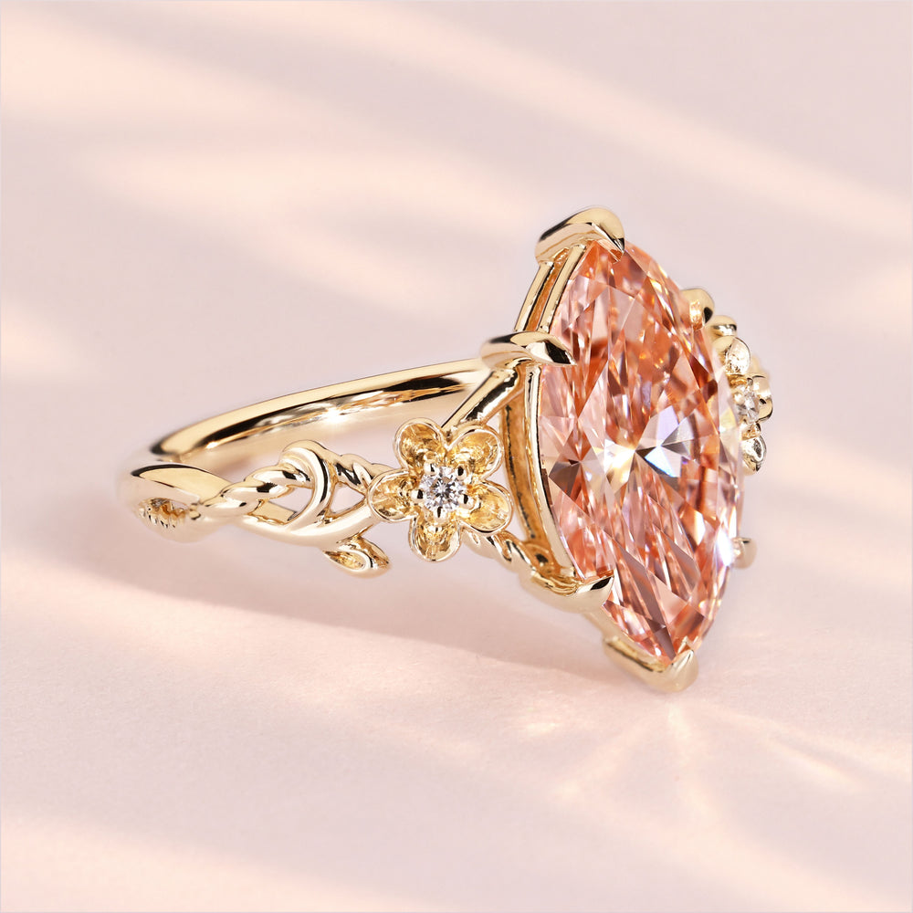 Marquise cut pink diamond ring with round side stones.
