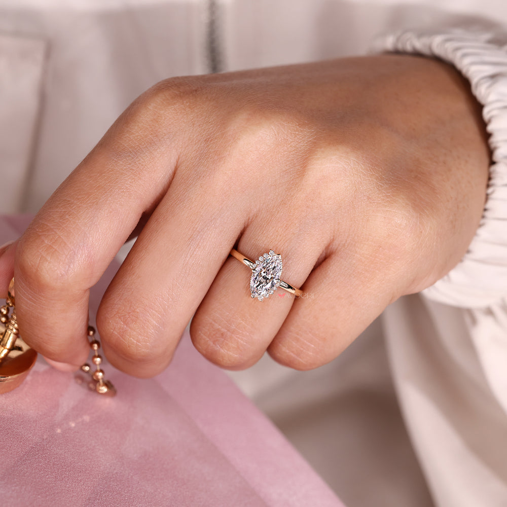 Marquise diamond cluster ring with milgrain detail.
