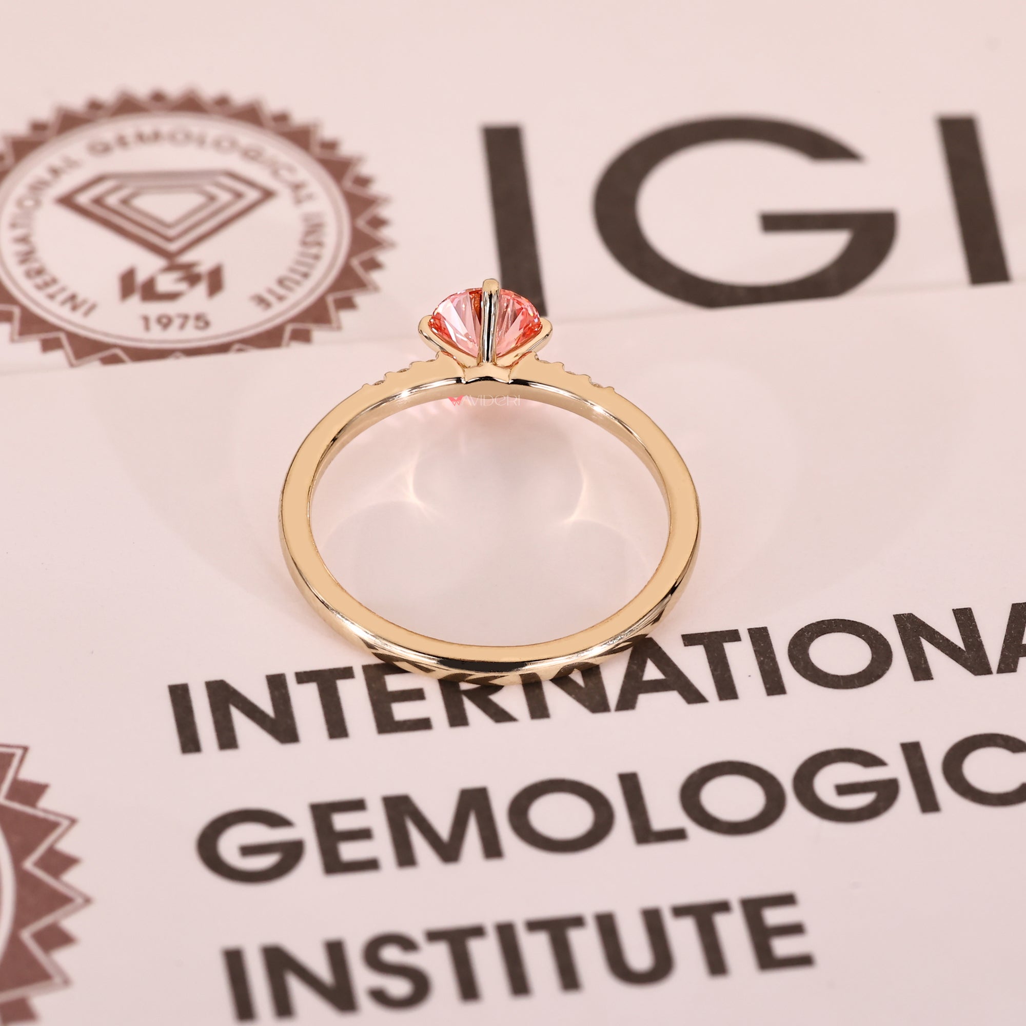 Yellow gold pink diamond ring with compass prong setting detail.