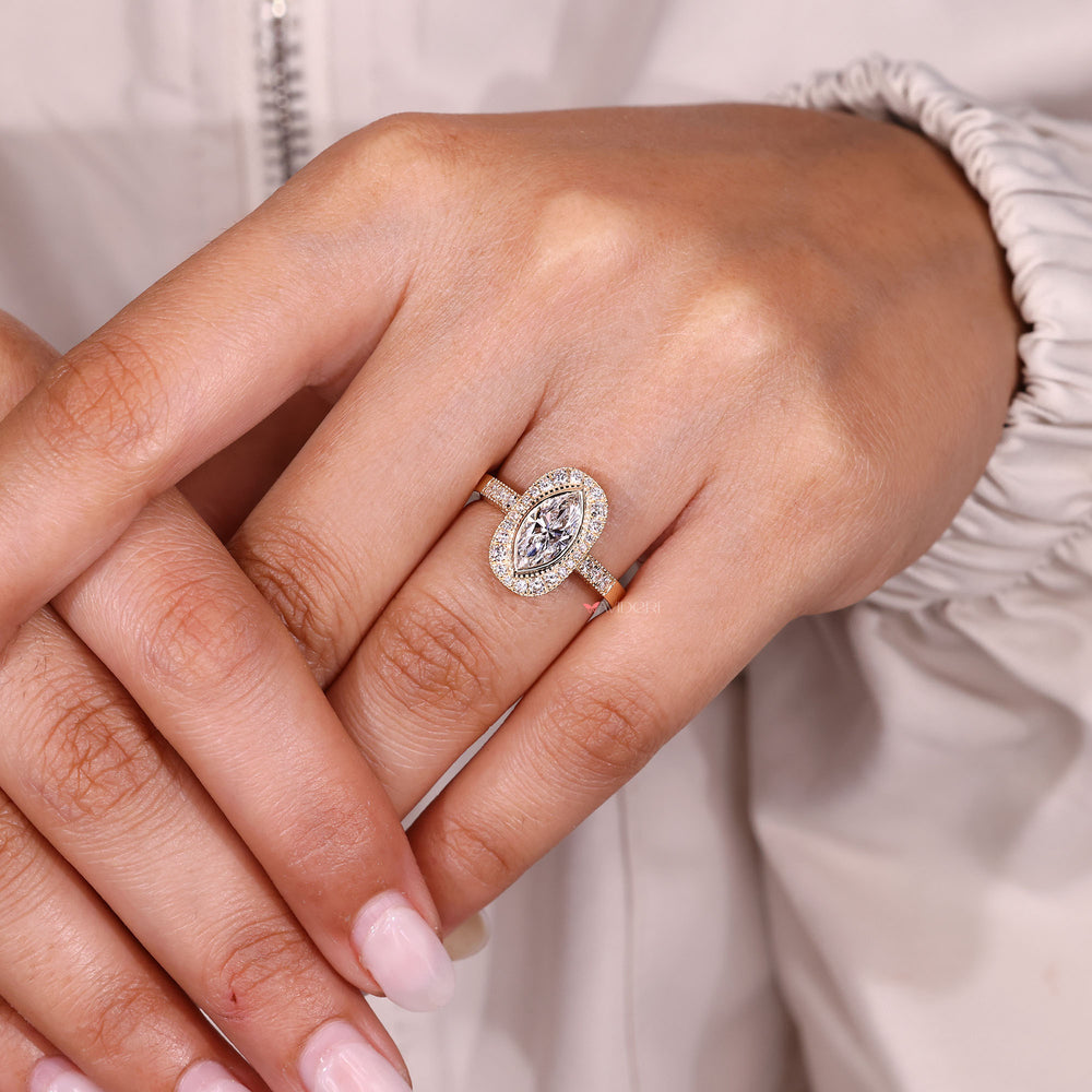 Marquise diamond halo ring with milgrain detail.
