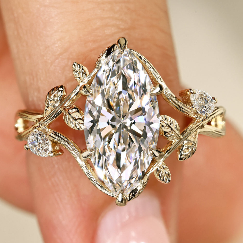 Botanical engagement ring with marquise diamond and pear side stones