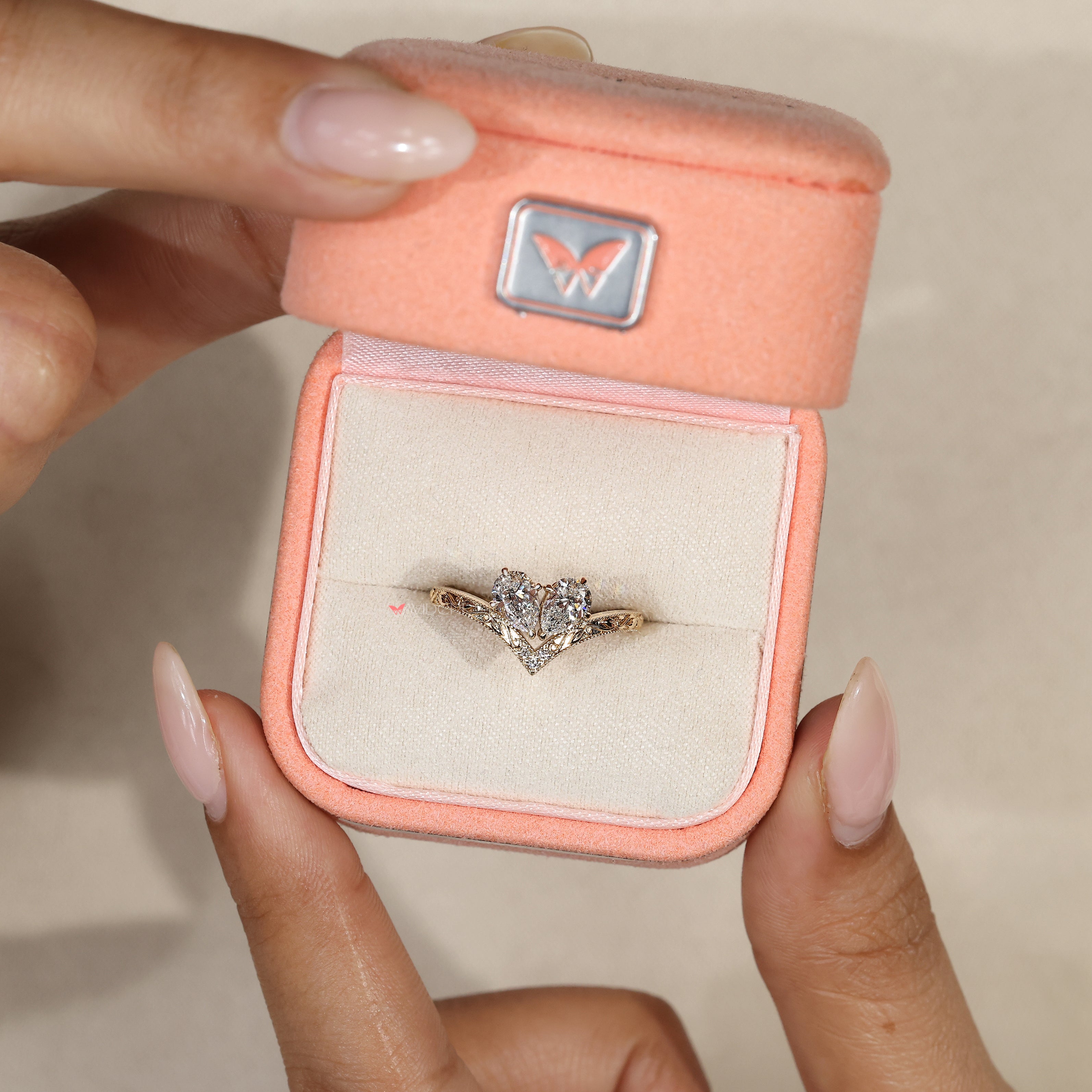 Milgrain pear diamond ring with round side stones.
