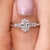 Oval diamond engagement ring features round cut side diamonds and a custom five stone layout.
