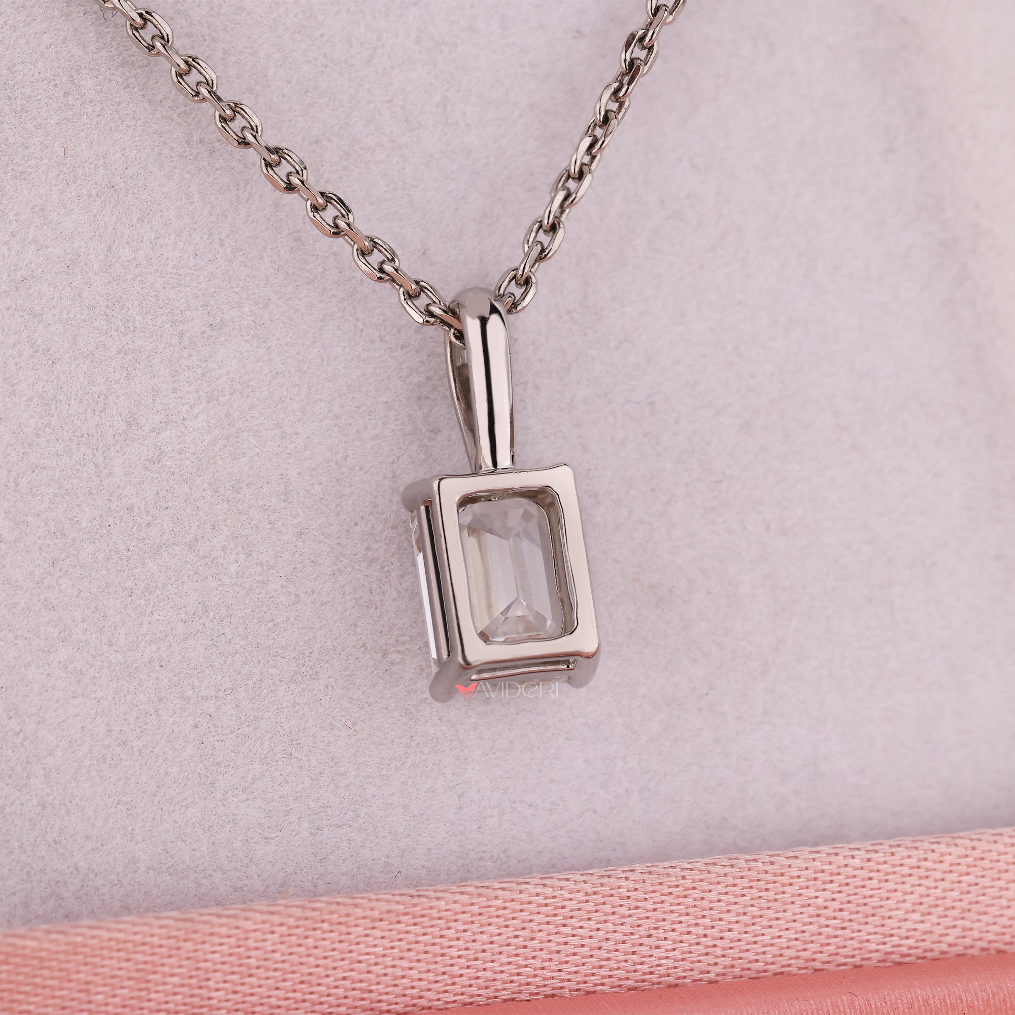 White gold pendant featuring emerald solitaire diamond stone.