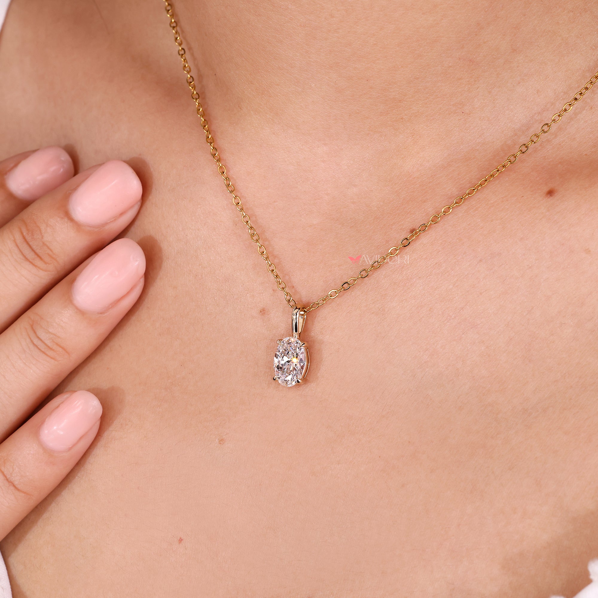 Solitaire pendant with oval cut diamond on fine gold chain.