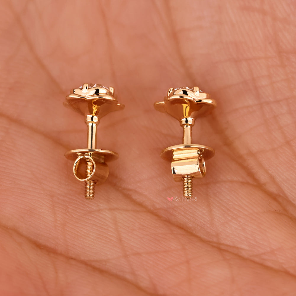 Flower shape diamond stud earrings with round stones.

