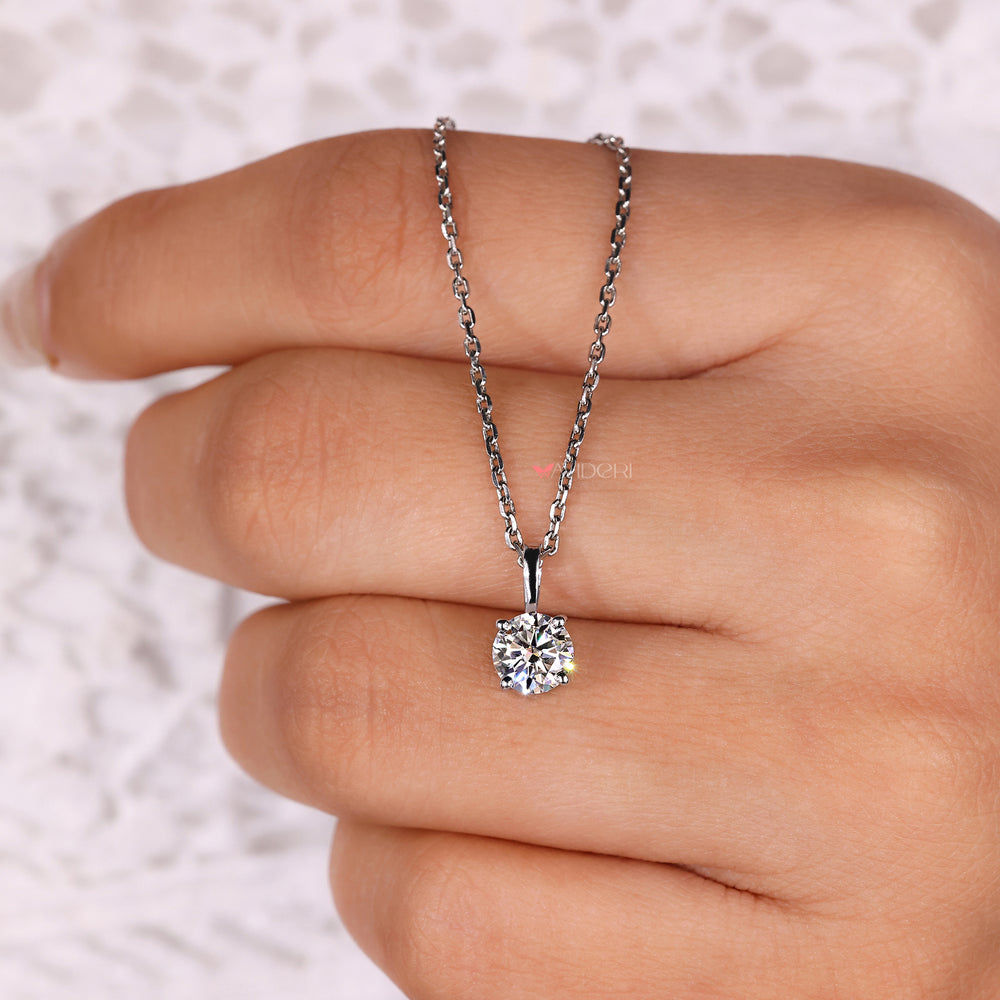 Round moissanite pendant in silver setting.